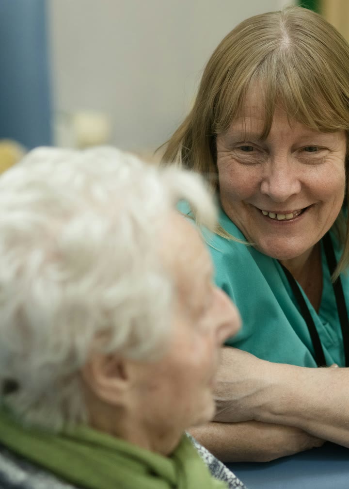 A caregiver sharing a laugh with an older woman